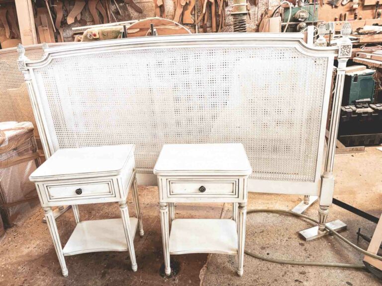Tête de lit en cannage rotin peint blanc avec tables de nuit assorties.